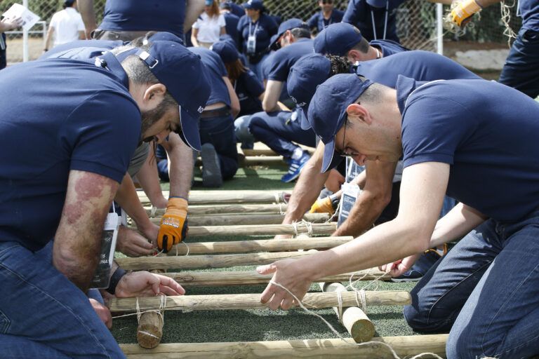 Grupo de personas creando una estructura de puentes en una actividad de team building