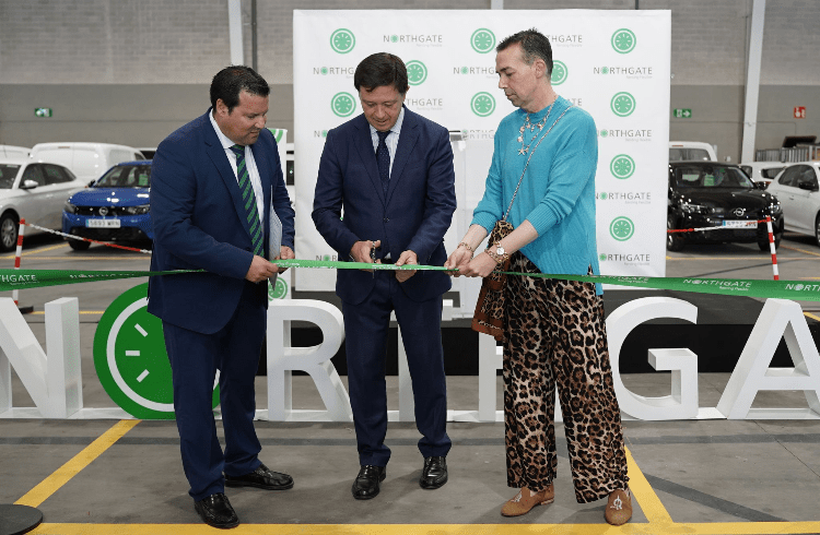 Tres personas cortan una cinta verde durante un evento de inauguración en un espacio de la empresa Northgate. Detrás se observan autos y un cartel con el logotipo de la compañía.
