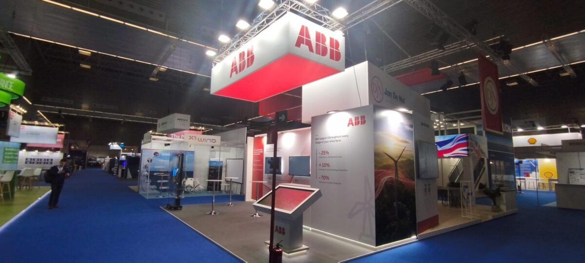 Stand de una corporación multinacional de tecnología y uno de los líderes mundiales en electrificación, automatización y robótica para feria wind europe, evento importante para la industria de la energía eólica, donde se reúnen empresas, expertos y responsables políticos para debatir sobre avances tecnológicos y políticas del sector.