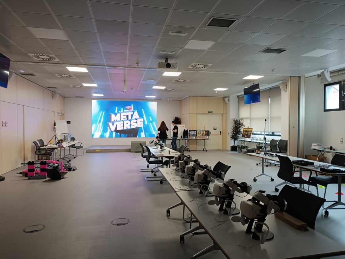 Sala moderna de formación o demostración tecnológica con mesas equipadas con visores de realidad virtual. Actividad de realidad virtual para team building.