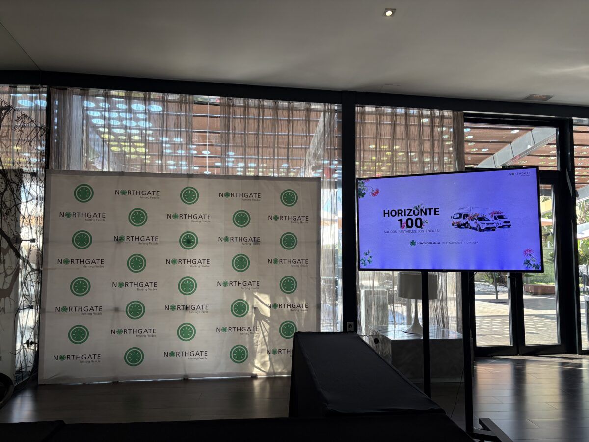 Escenario de un evento corporativo con un photocall de Northgate Renting Flexible y una pantalla con el logotipo "Horizonte 100".