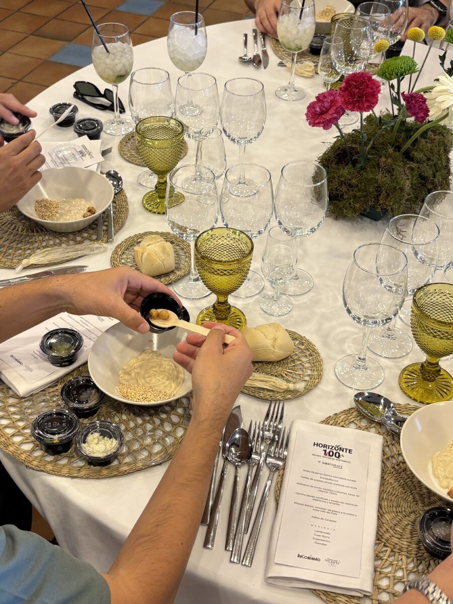 Primer plano de una mesa de banquete decorada, mostrando vajilla, copas de cristal, un centro de flores y el menú del evento de Northgate.